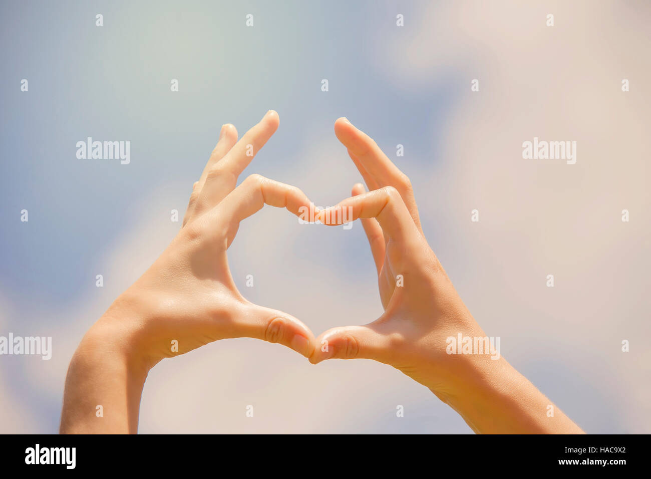 Symbol of love, human hands in heart shape towards blue sky Stock Photo ...