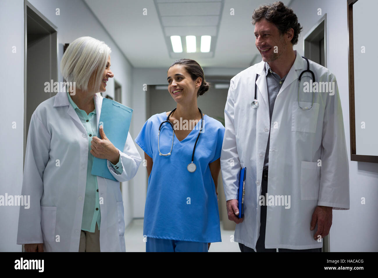 Doctors and surgeon interacting in corridor Stock Photo - Alamy