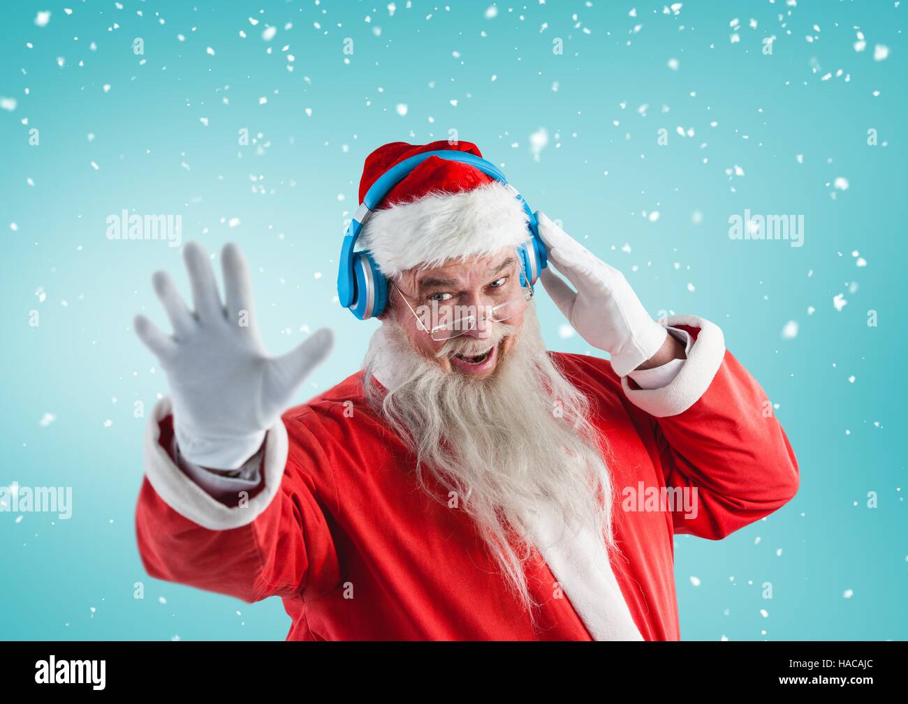 Santa gesturing while listening music on headphones Stock Photo