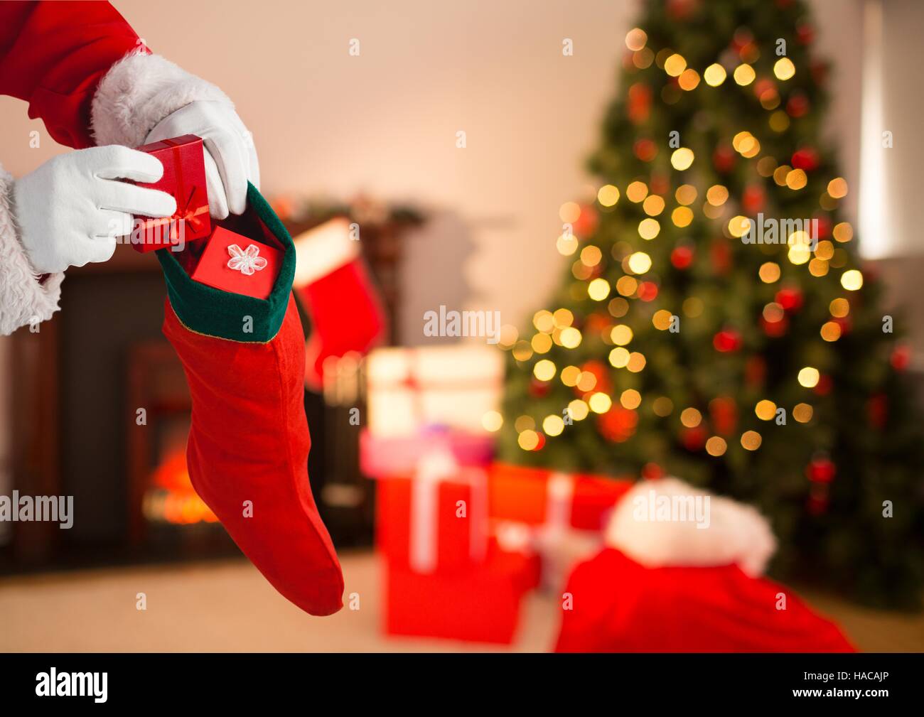 Santa Claus putting gifts in Christmas stocking Stock Photo Alamy