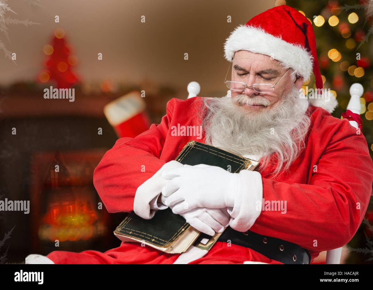 Santa claus with a diary sleeping on a chair Stock Photo