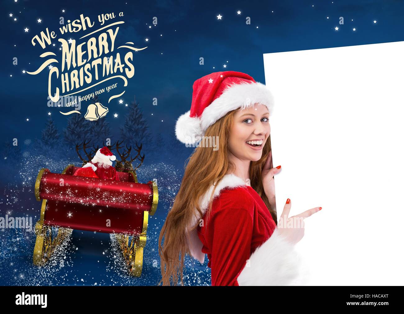 3D Woman in santa costume pointing at placard with santa claus riding reindeer sleigh towards the sk Stock Photo
