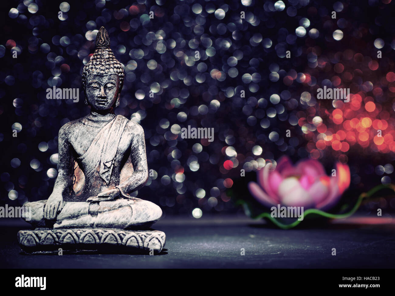 Buddha statue and a orchid flower on a bright shiny background with