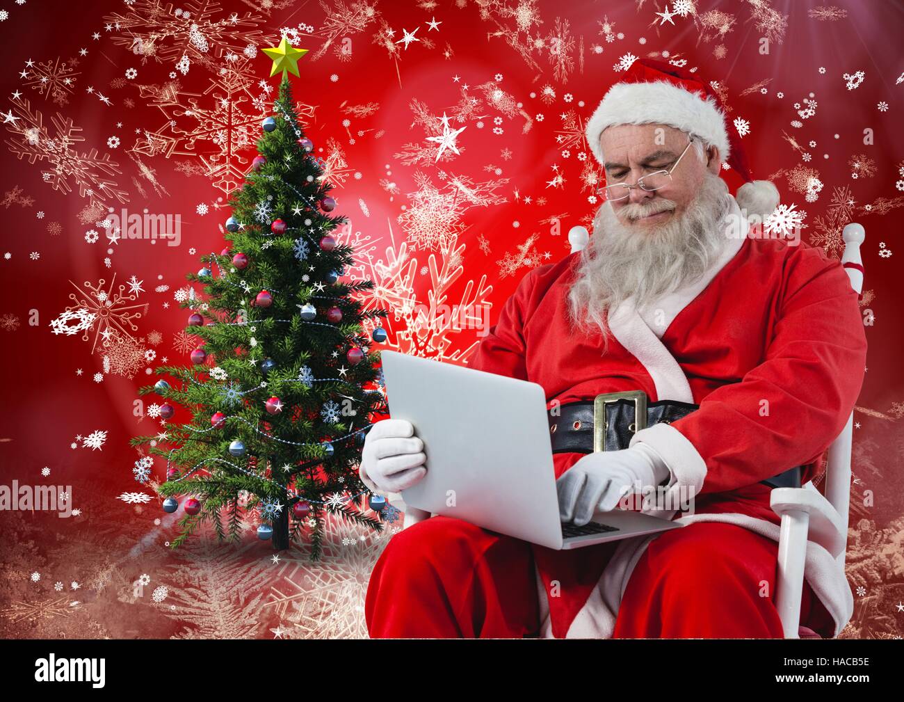 Santa sitting on chair and using laptop Stock Photo