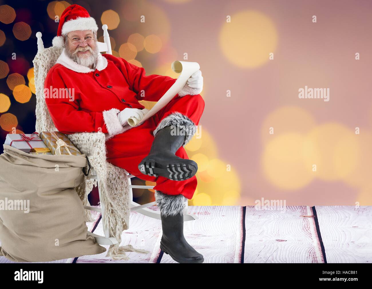 Santa claus holding wish list with sack of gifts Stock Photo