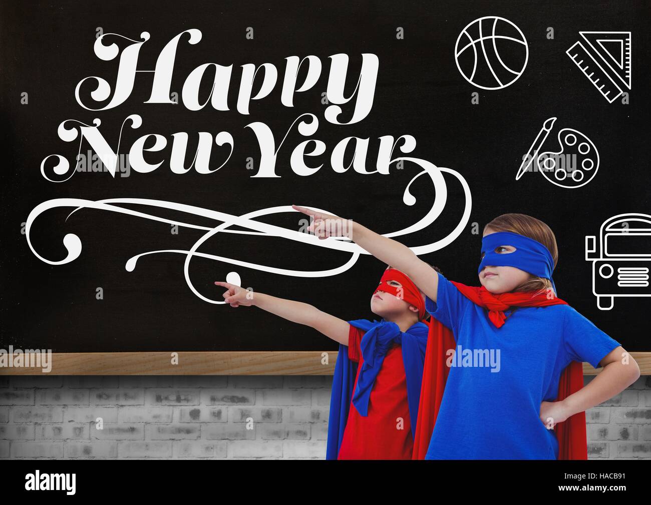 Children in super hero costumes pointing at new year greeting quotes Stock Photo