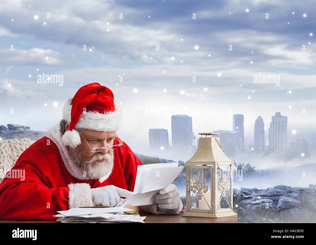 Santa sitting at table and reading christmas letter Stock Photo
