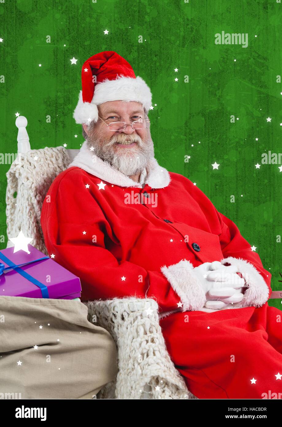 Smiling santa claus sitting with gift sack Stock Photo