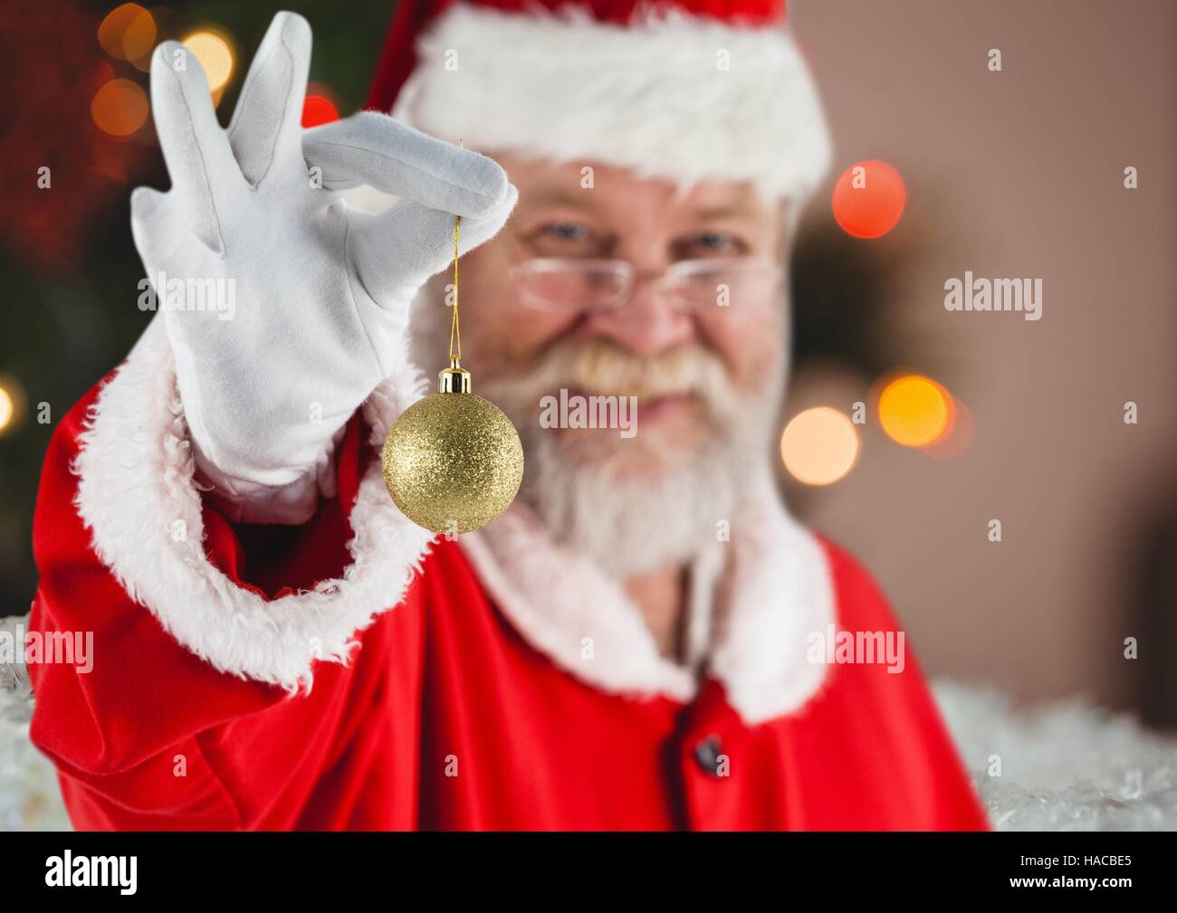 Santa holding christmas bauble Stock Photo - Alamy