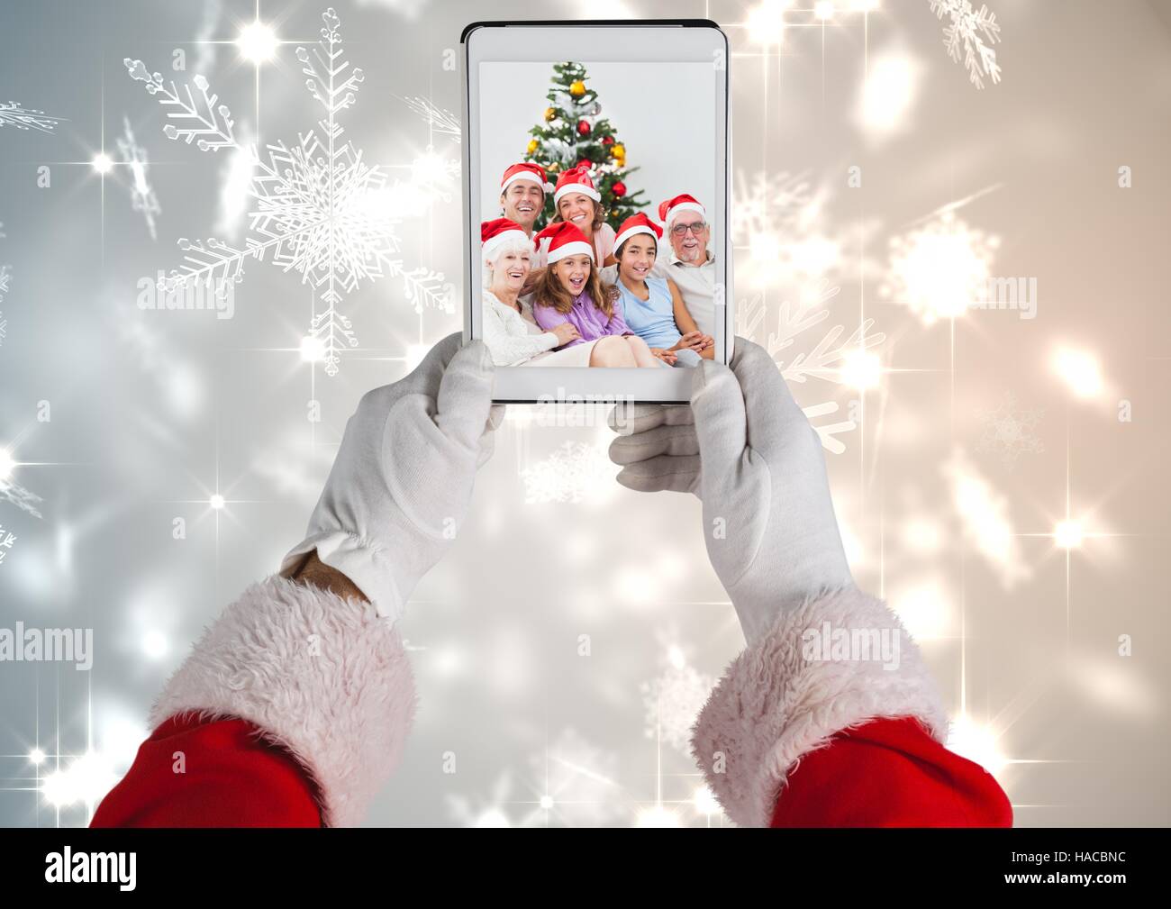 Santa claus holding a digital tablet with photo of christmas family Stock Photo