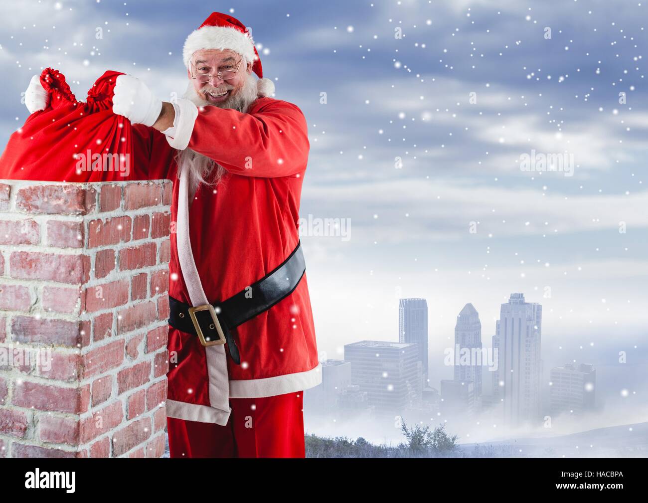 Santa removing gift sack from chimney Stock Photo