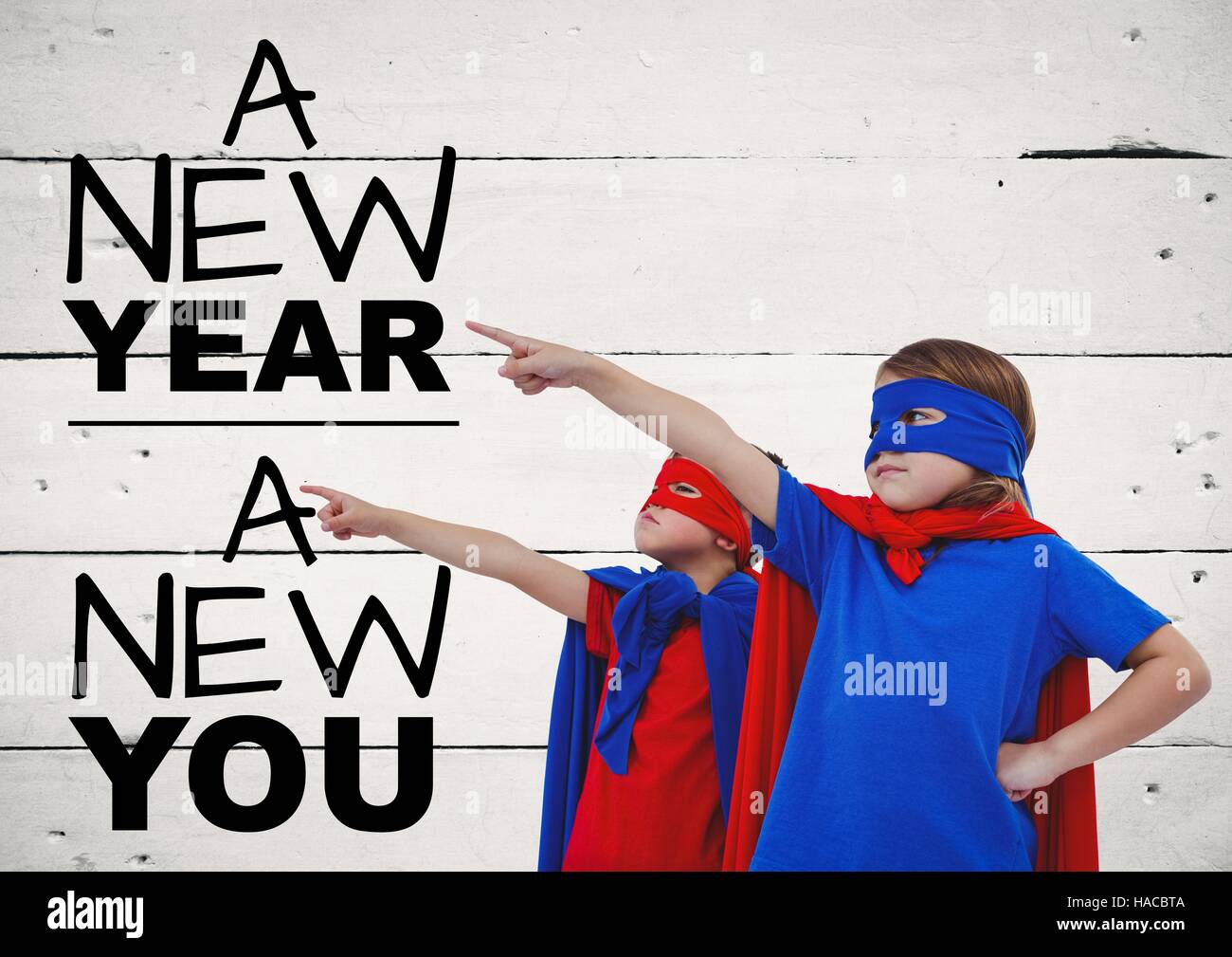 Children in super hero costumes pointing at new year greeting quotes Stock Photo