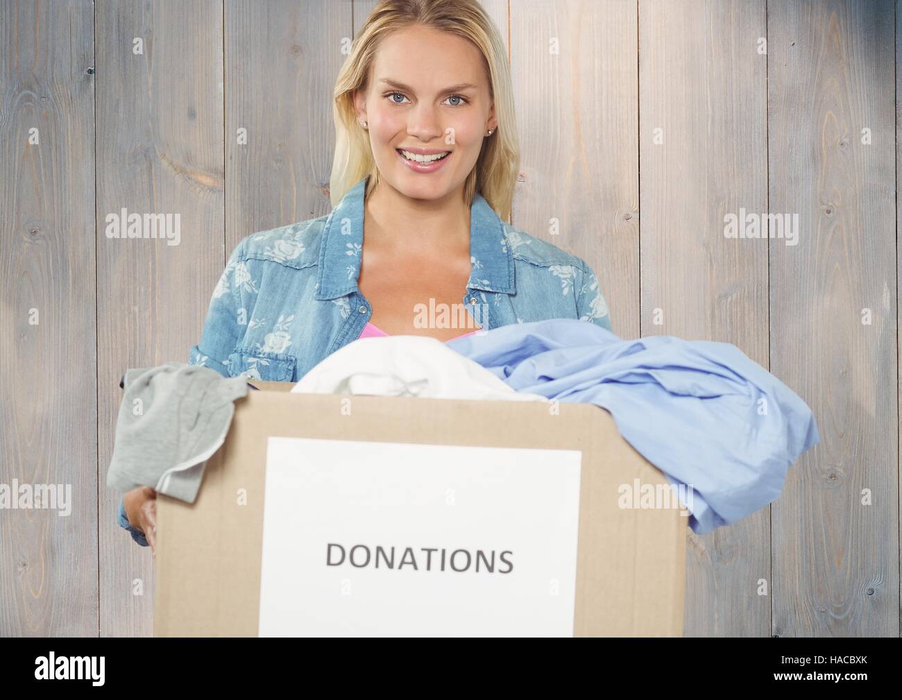 Smiling female volunteer holding donations box Stock Photo