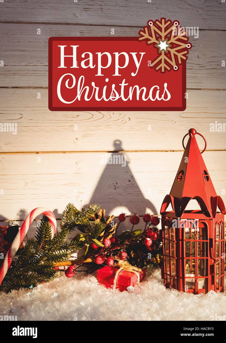 Happy christmas message on wooden background against christmas decoration Stock Photo