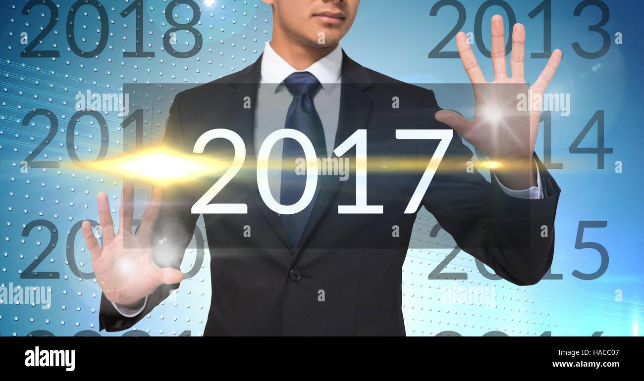 Business man in digitally generated background touching 2017 Stock Photo