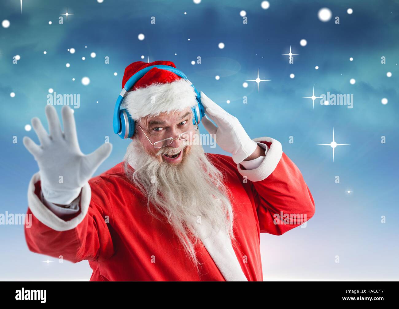 Happy santa gesturing while listening music on headphones Stock Photo