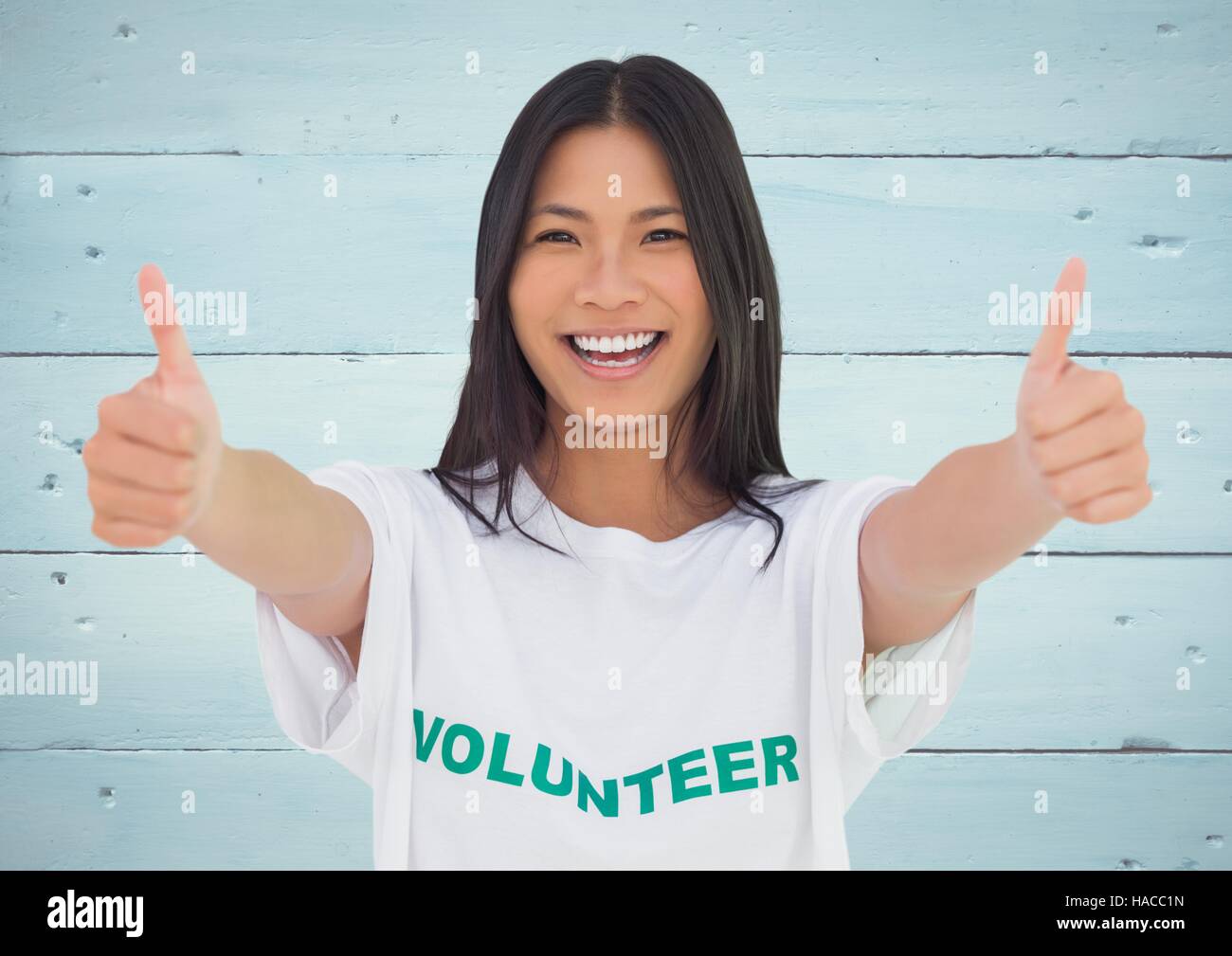 Smiling female volunteer showing thumbs up Stock Photo