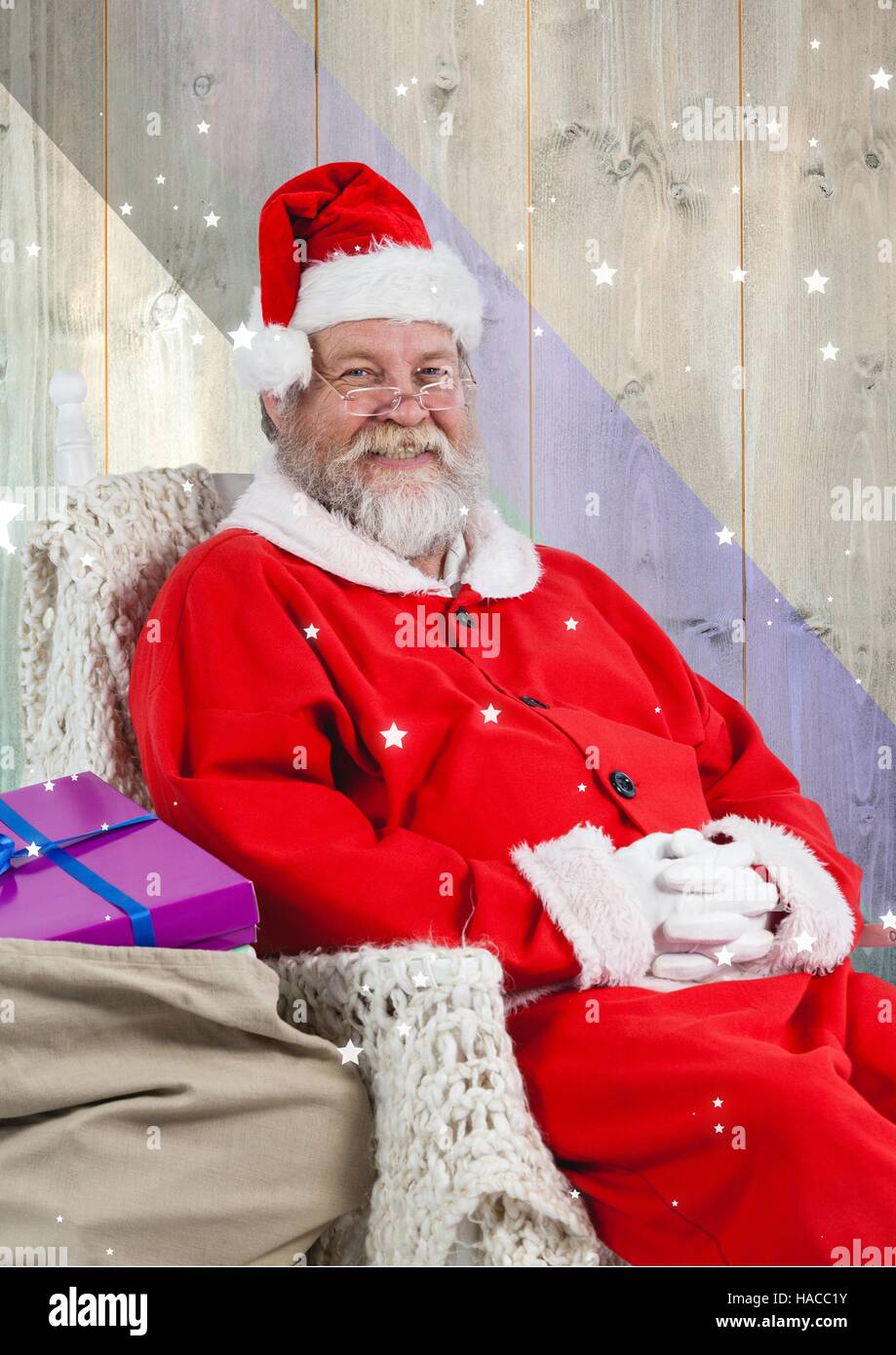 Smiling santa claus sitting with gift sack Stock Photo