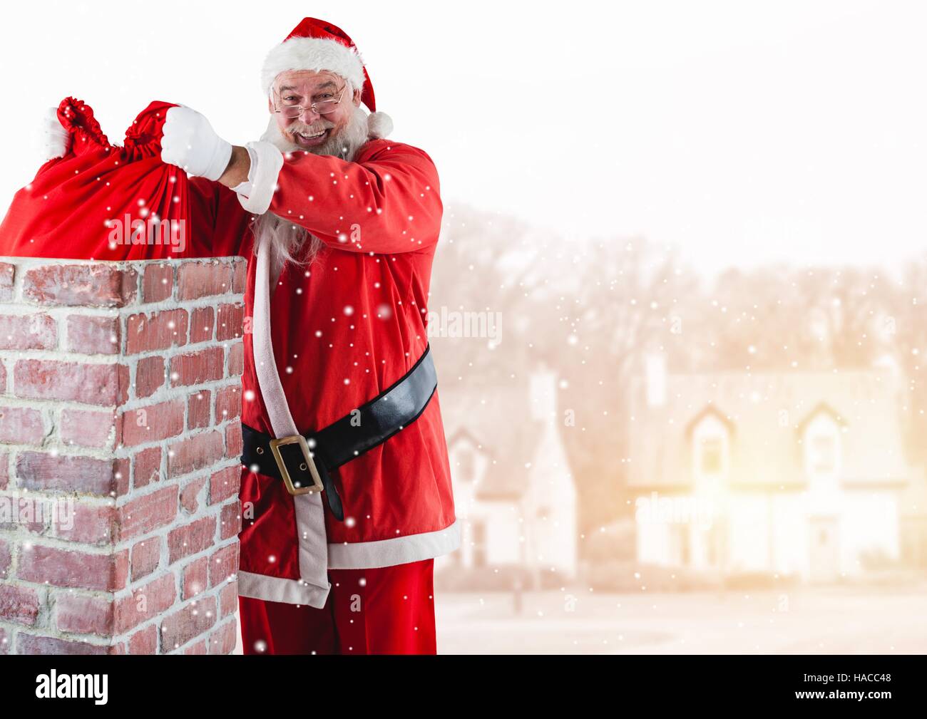 Santa removing gift sack from chimney Stock Photo