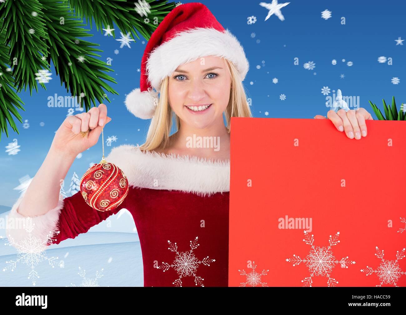 Beautiful woman in santa costume holding red placard and bauble Stock Photo
