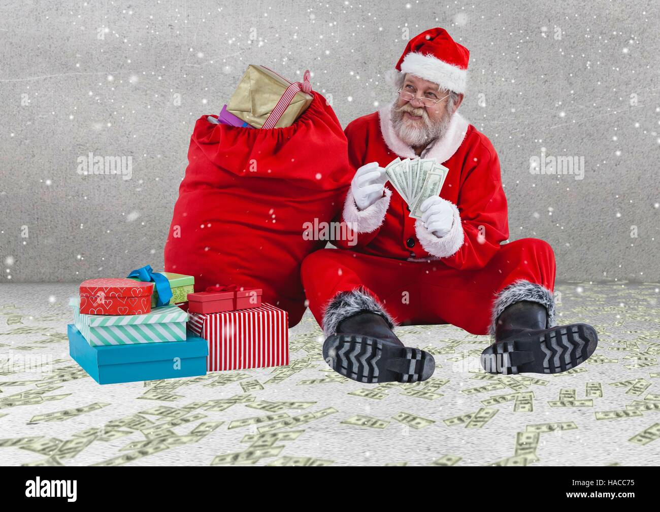 Happy santa claus with currency notes sitting next to christmas gifts Stock Photo