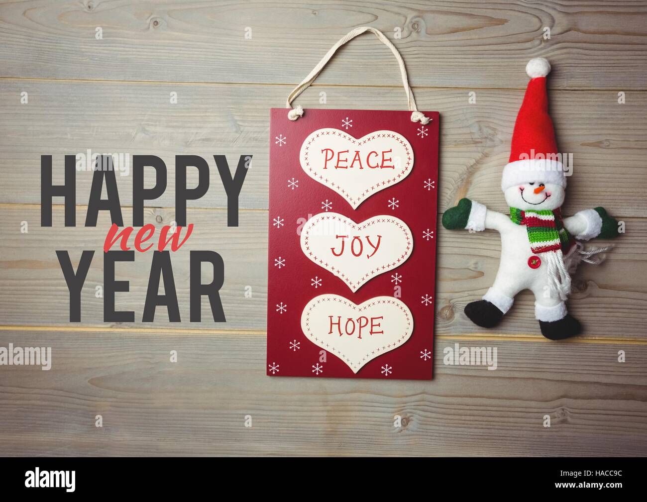 Happy christmas message on wooden background with shopping bag and snowman Stock Photo