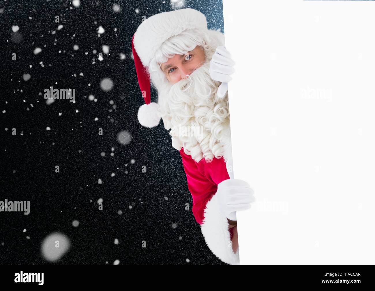 Santa peeking out from behind the wall Stock Photo