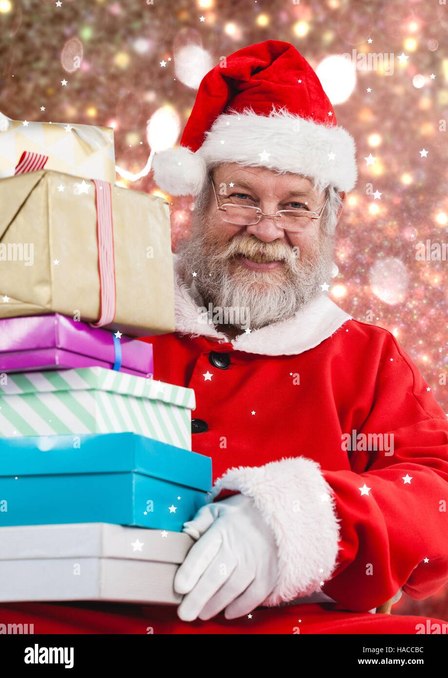Santa holding stack of christmas gifts Stock Photo
