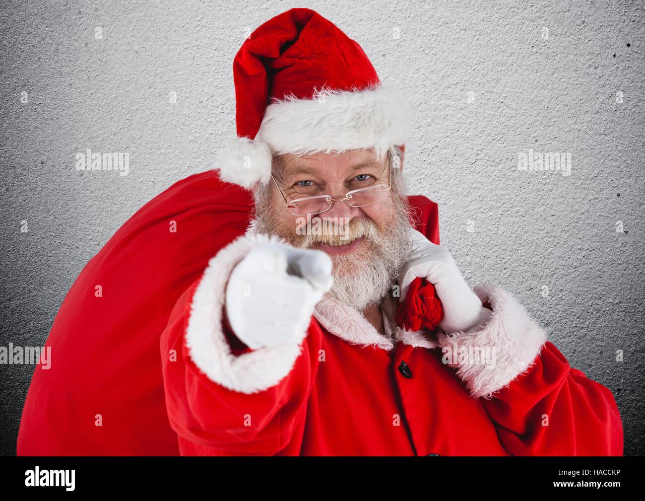 Santa claus with gift sack pointing towards camera Stock Photo