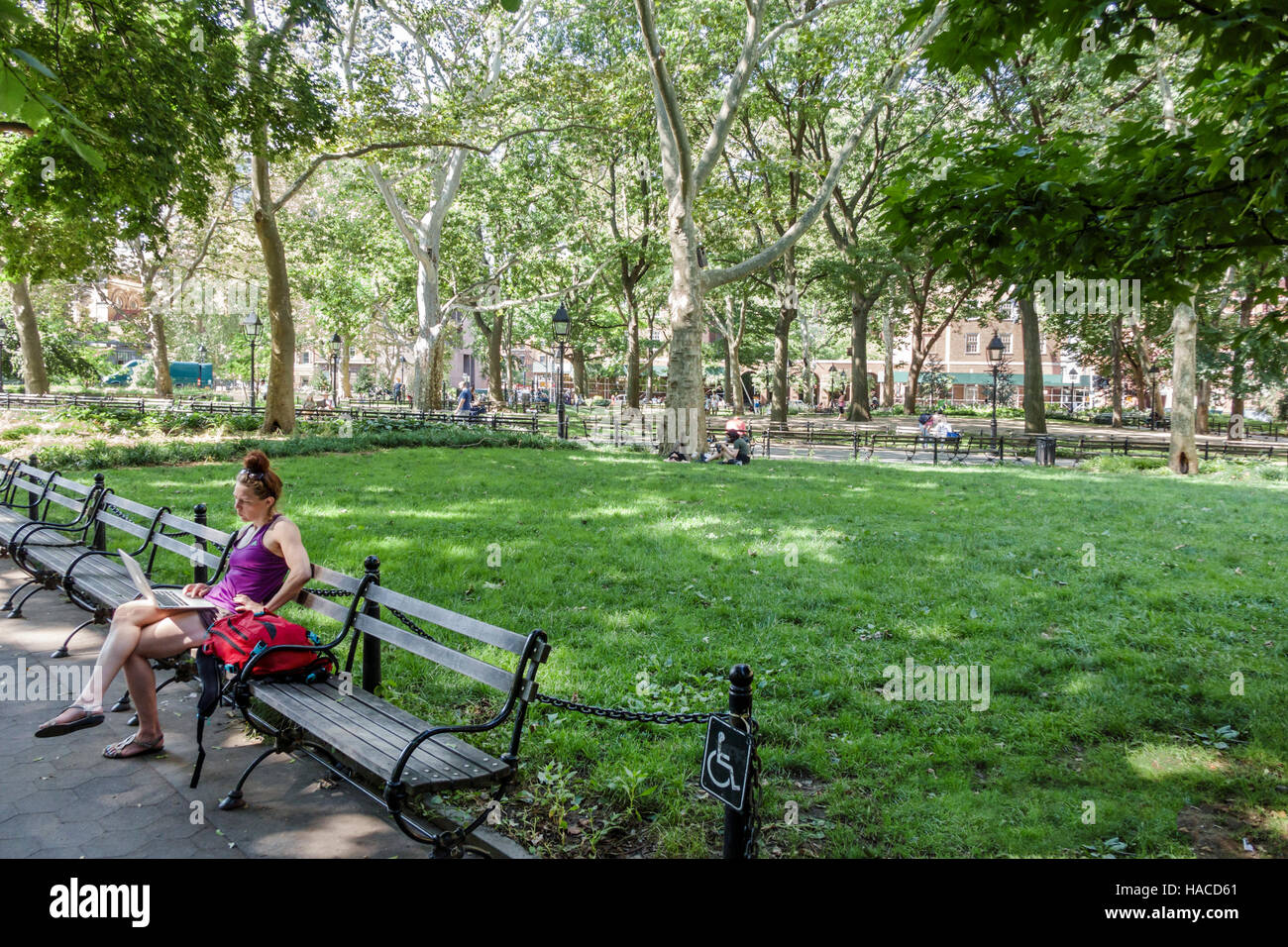 New York City,NY NYC Manhattan,Greenwich Village,Washington Square Park,public park,bench,adult adults,woman female women,laptop,sitting,lawn,trees,NY Stock Photo