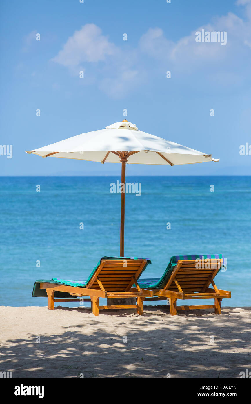 Two lounge chairs with sun umbrella on a beach Stock Photo Alamy