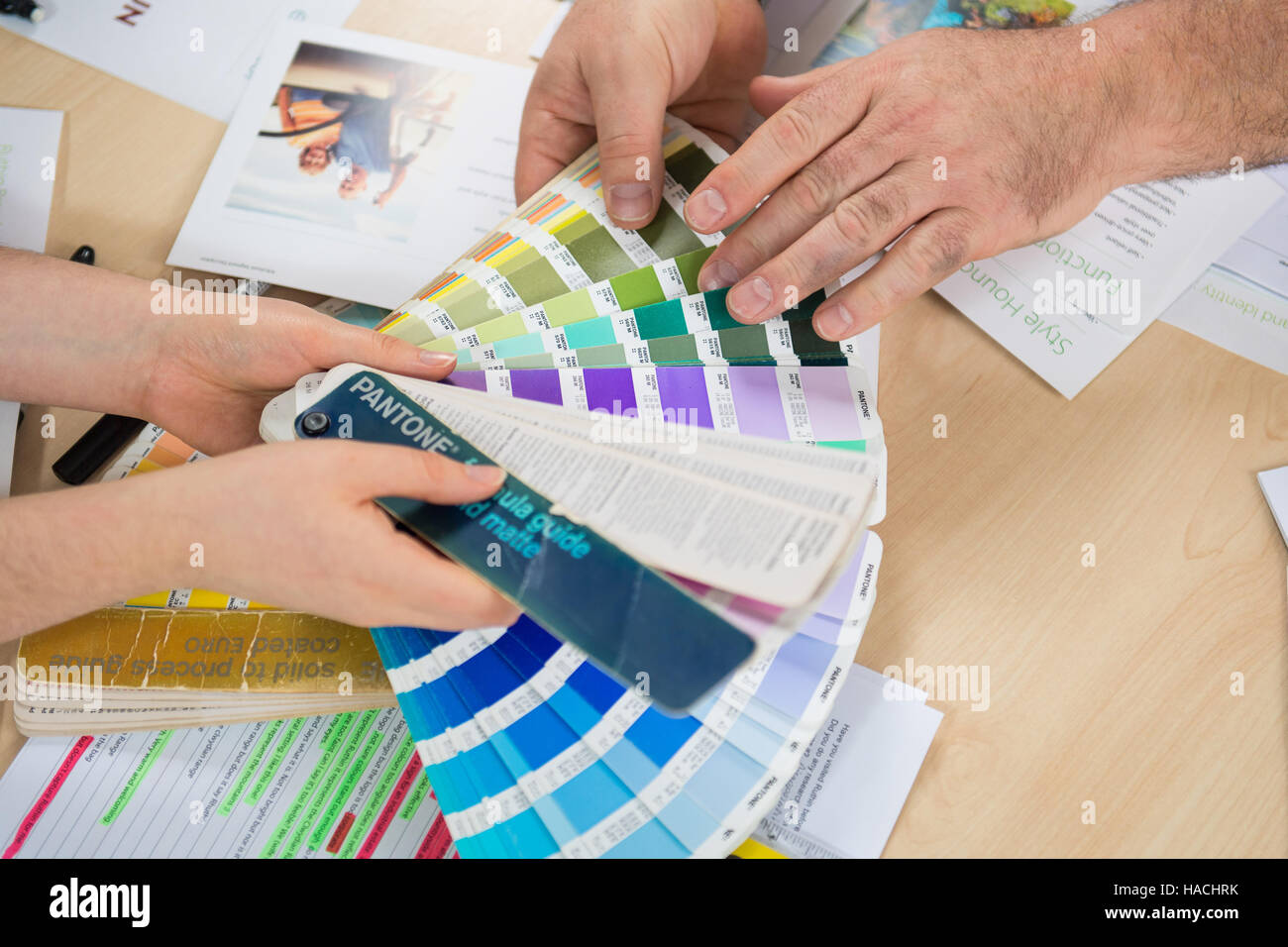 Graphic designers choosing from a Pantone colour fan deck Stock Photo -  Alamy