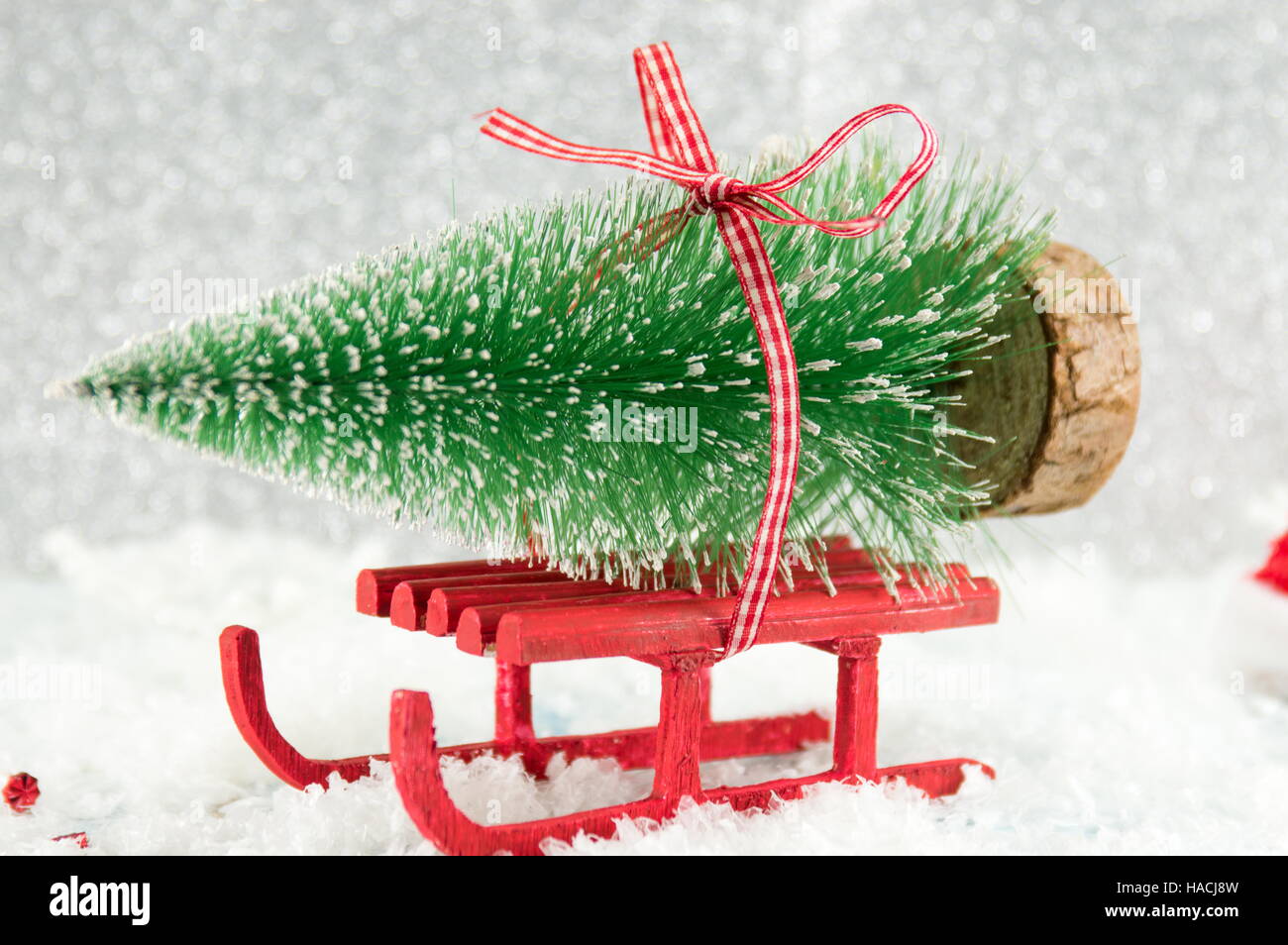 Red winter sleigh carrying a small Christmas tree Stock Photo