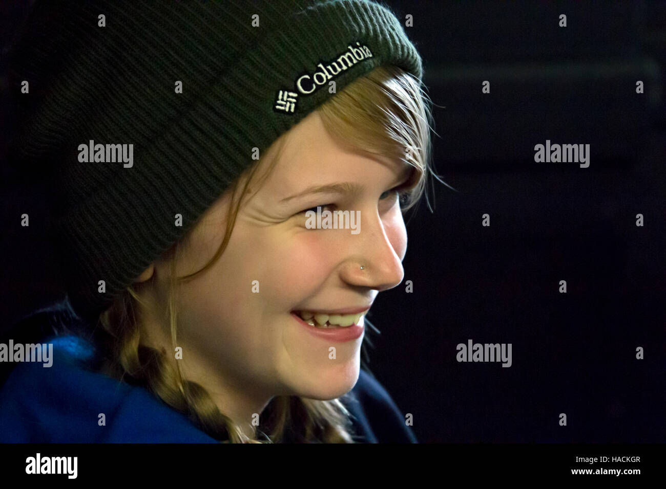 Close up of a young teen girl not looking at camera and smiling. Stock Photo