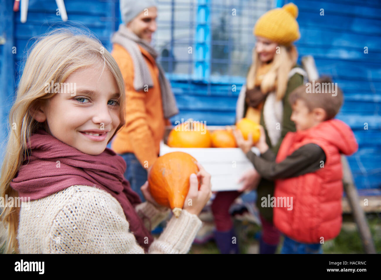 Little girl with family during the autumn harvest Stock Photo