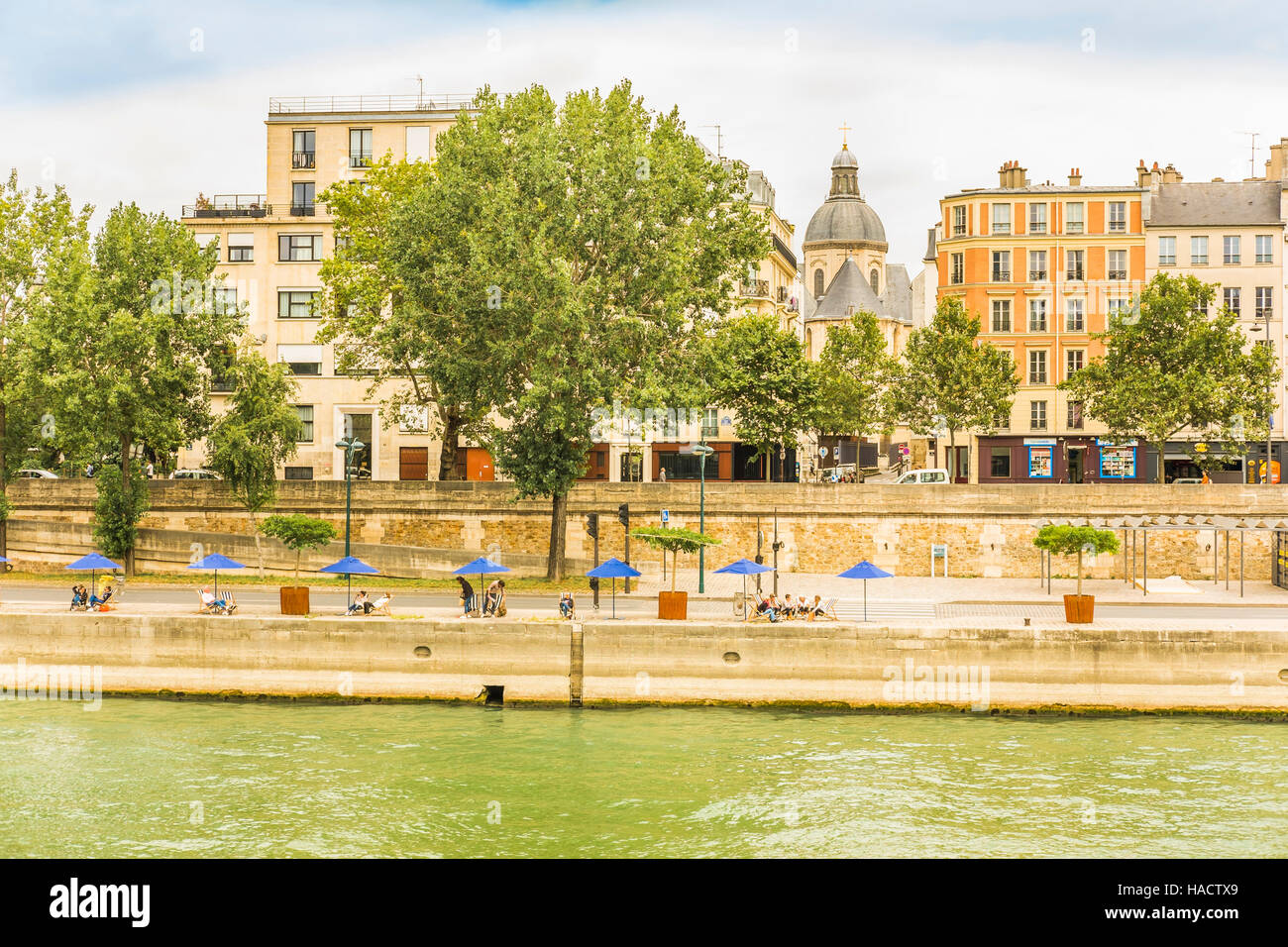 people taking a break under blue  paris plage  umbrellas on the banks of river seine Stock Photo