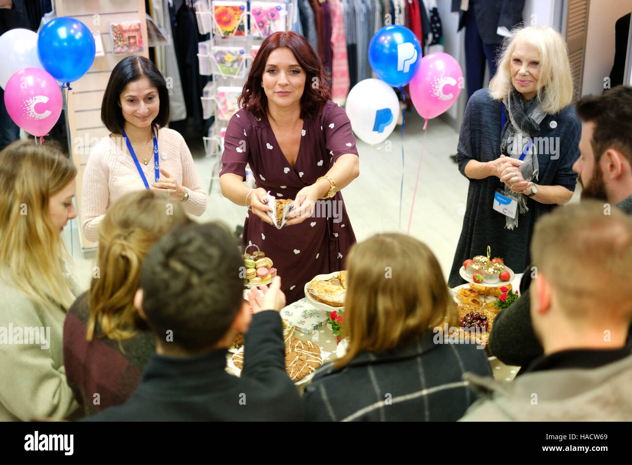 EDITORIAL USE ONLY Candice Brown (centre), winner of the Great British Bake Off, surprises customers at a charity bake sale to celebrate Giving Tuesday, which is an alternative to Black Friday with people around the world being encouraged to do a good deed for charity. Stock Photo