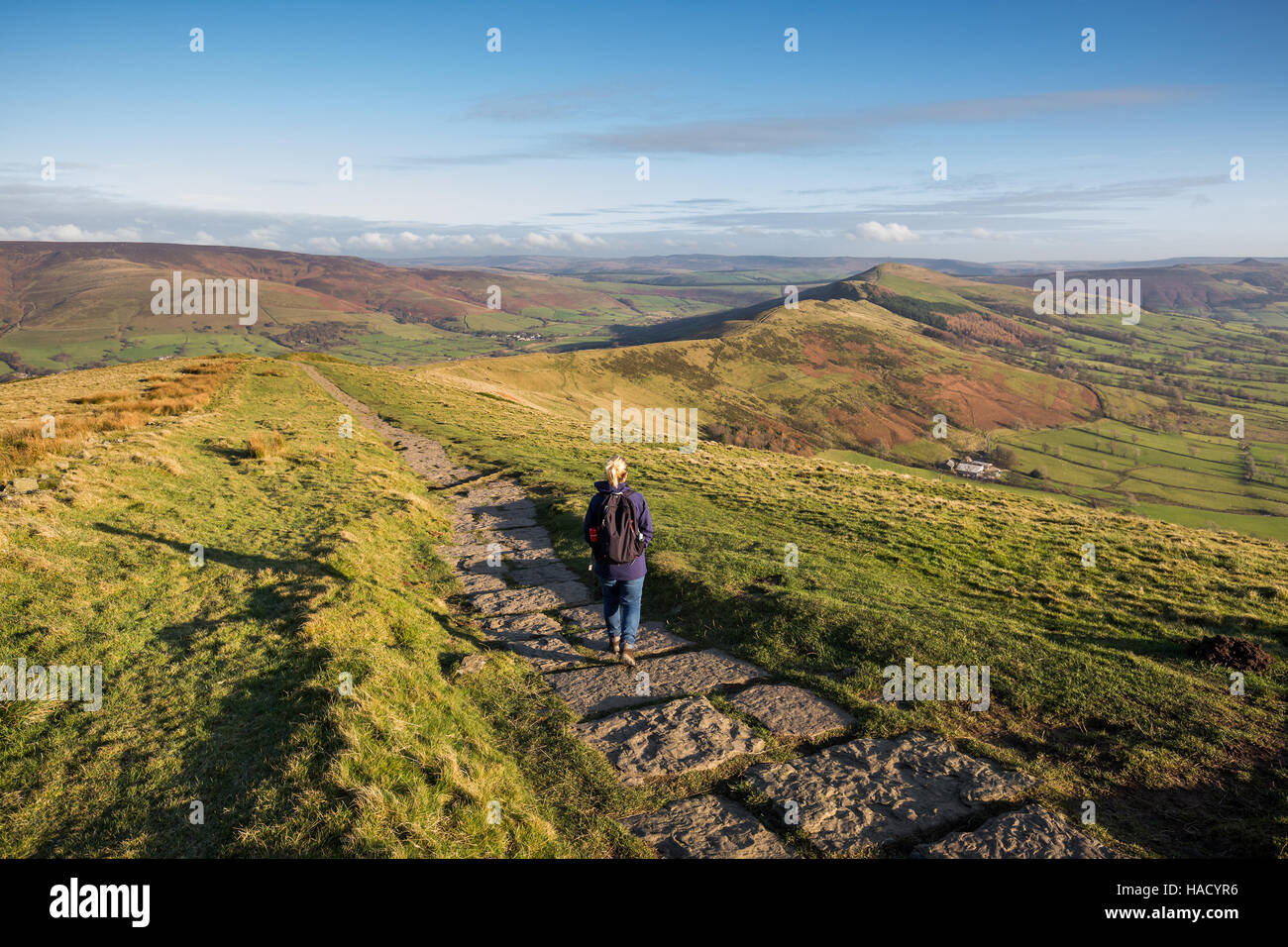 Woman walking the stone path from Mam Tor to Hollins Cross near Castleton in the Peak District, Derbyshire, UK. Stock Photo