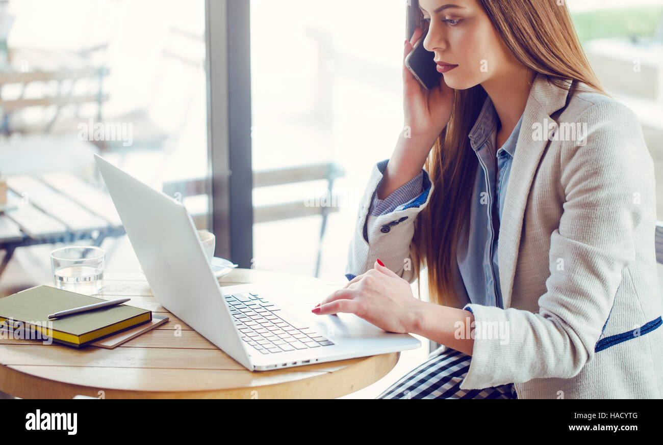 Beautiful Young Woman Working on Laptop in Coffee Shop Stock Photo - Alamy