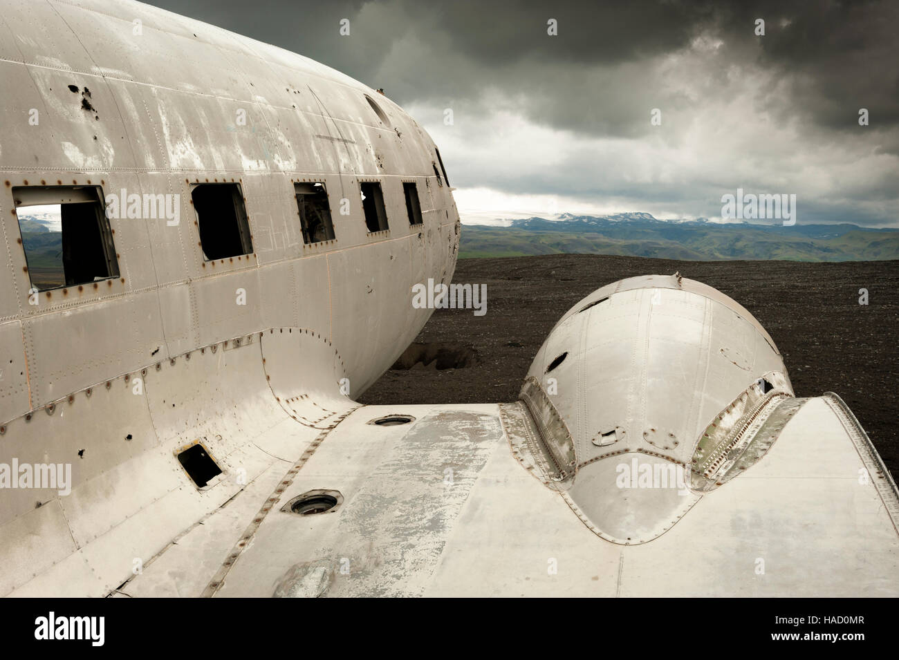 Iceland - Solheimasandur United States Navy aeroplane wreck facing the mountains and heavy storm clouds in the background Stock Photo