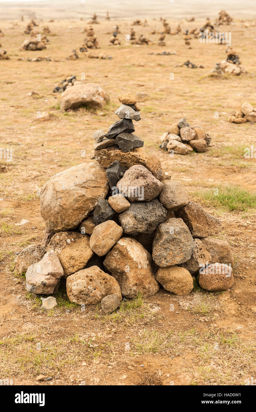 Several cairns (piles of rocks, stones) built over an open field in Thingvellir / Þingvellir National Park in Iceland. Stock Photo