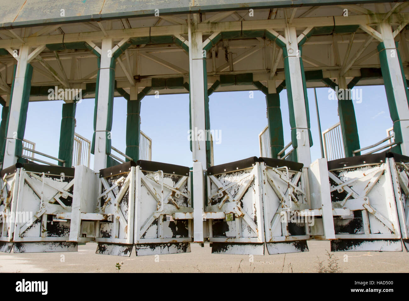 Empty horse racing starting gate rusting against blue skies. Stock Photo