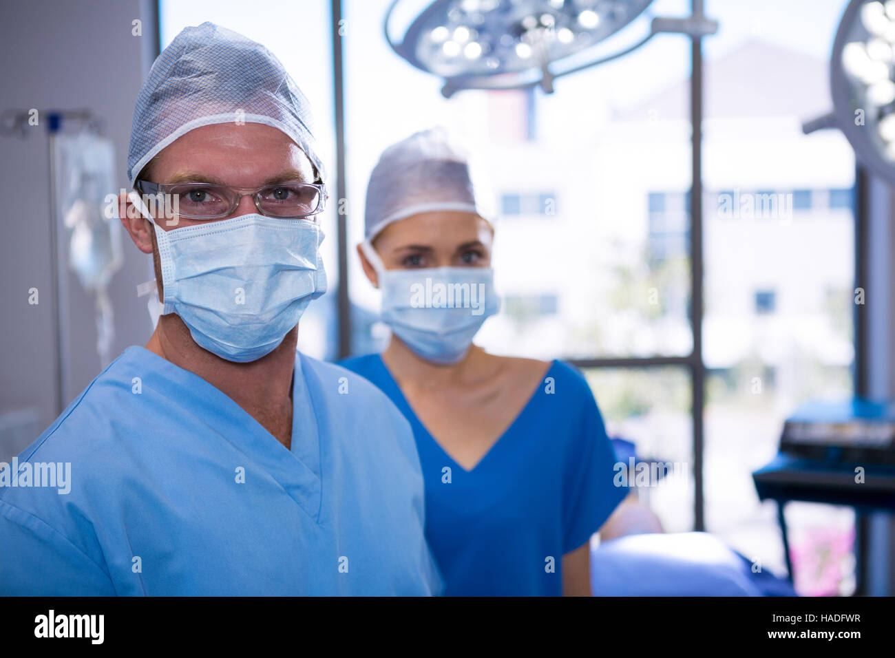 Portrait of male and female nurse wearing surgical mask in operation ...