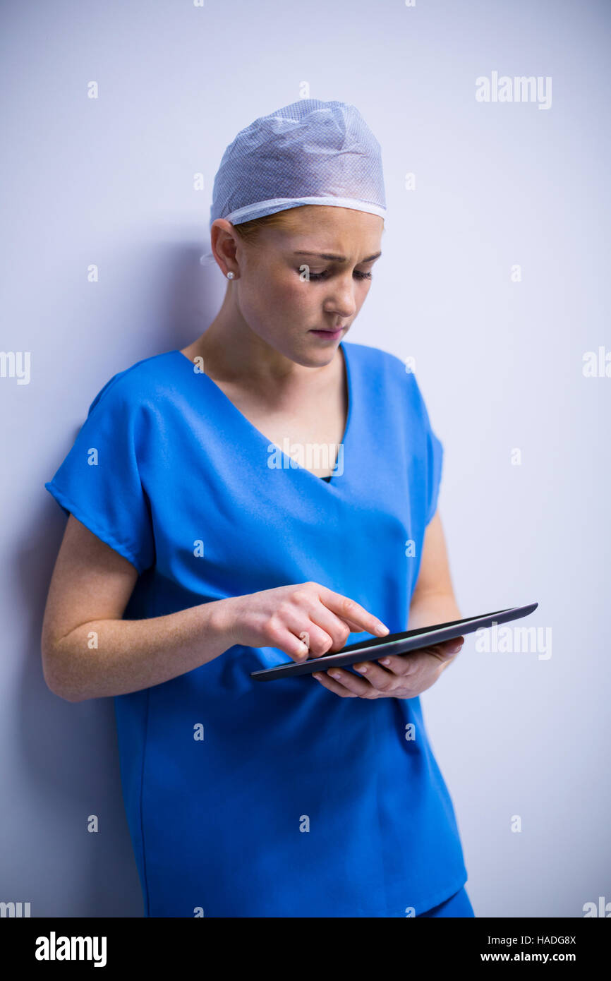 Female nurse using digital tablet in corridor Stock Photo - Alamy