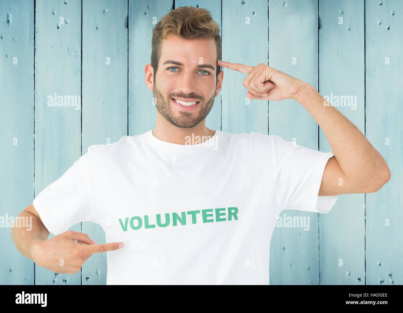 Smiling man in volunteer tshirt pointing at head stock photo alamy