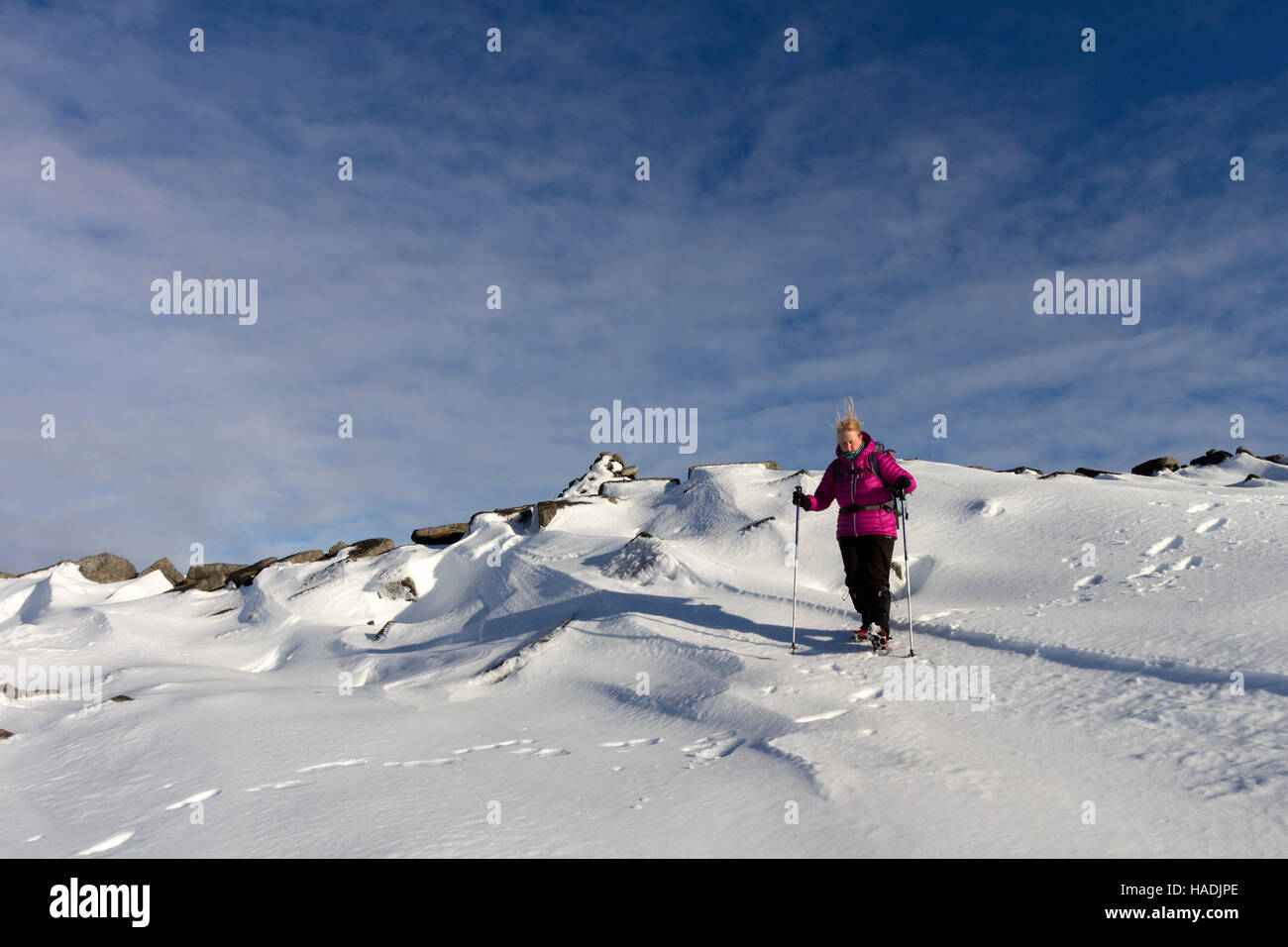 Walker with Hair Blown Vertically Experiencing Updraft as the Wind Accelerates Over the Summit Plateau of Cross Fell in Winter Stock Photo