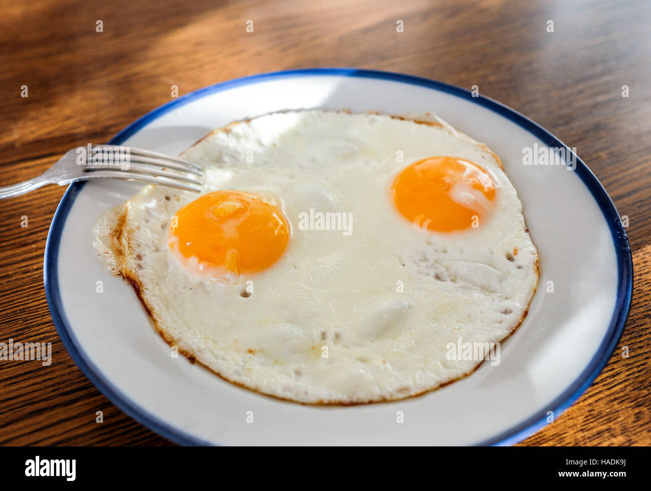 Fried eggs like a smiley face on the tray with the light blue platter Stock Photo