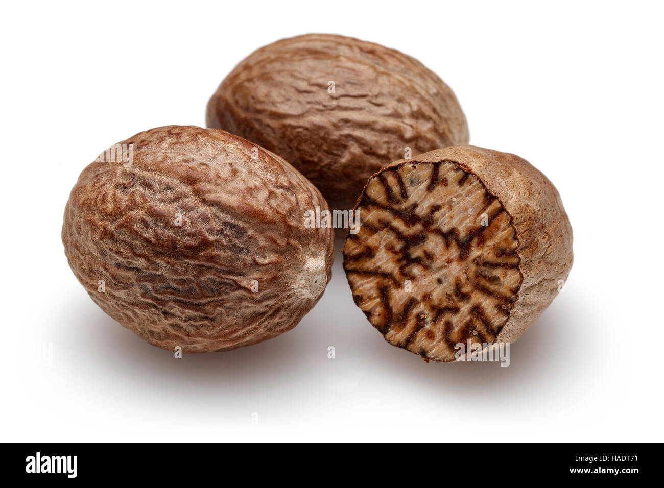 Nutmeg and half nutmeg on white background Stock Photo Alamy