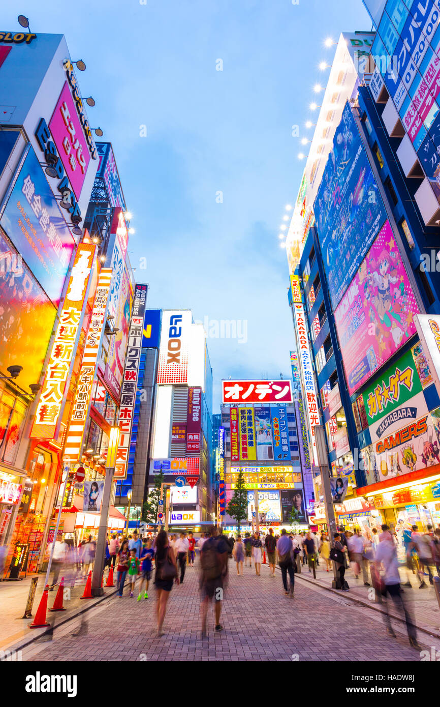 Bright neon lights and billboard advertisements on building sides in busy Akihabara electronics hub during blue hour on a summer Stock Photo