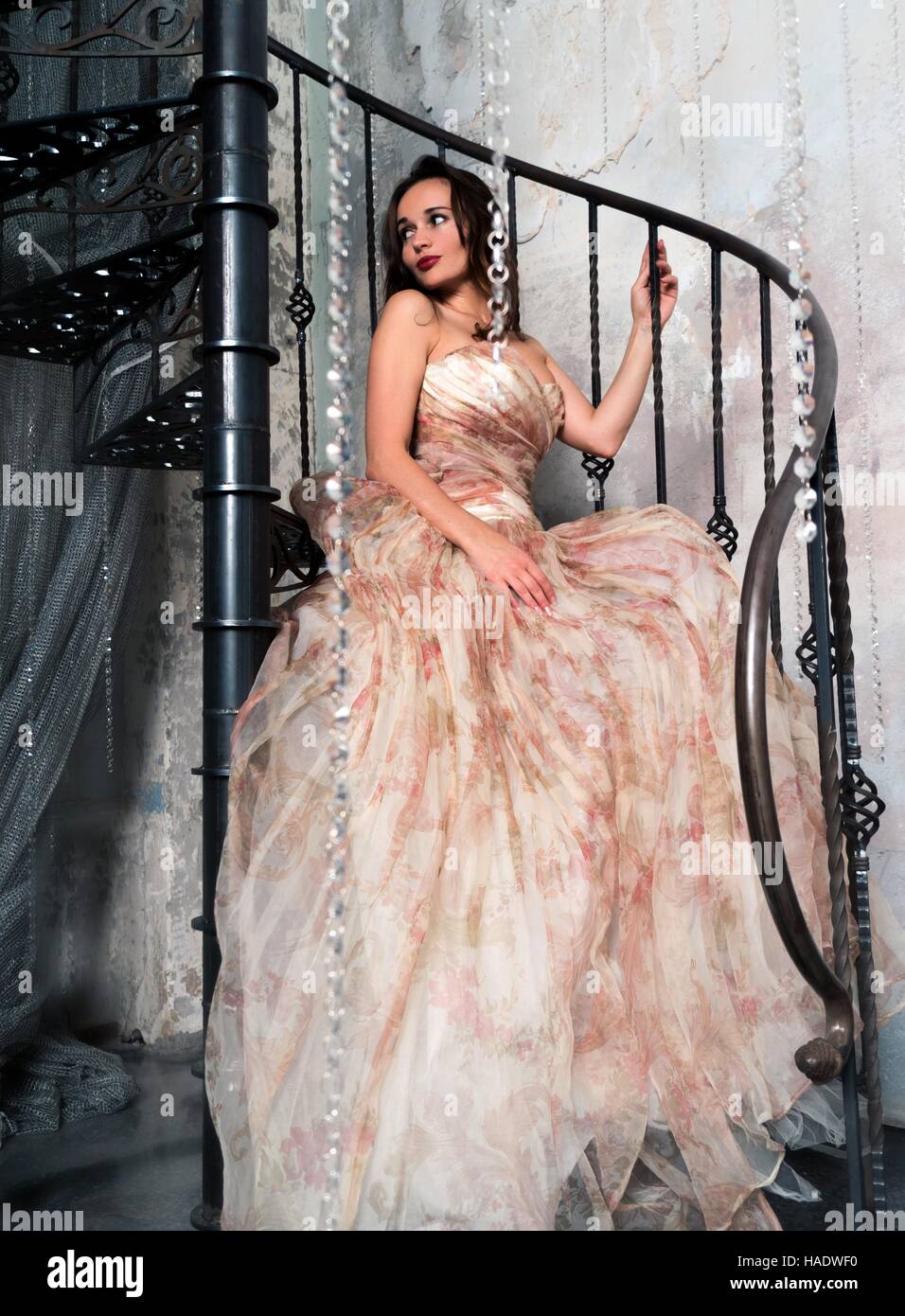 Woman in large dress sitting on a spiral staircase Stock Photo - Alamy